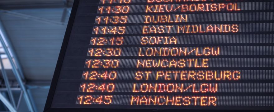 A low-angle shot of a departure board at an airport